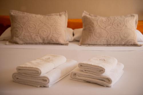 two towels and two pillows on a bed at Patagonia Hotel in San Carlos de Bariloche