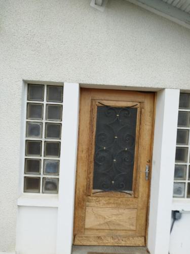 a wooden door with a window in a house at Espace Fakayo in LʼIsle-dʼEspagnac