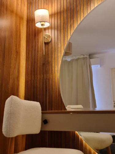 a bathroom with a mirror and a white chair at Garden view apartment in Madinaty