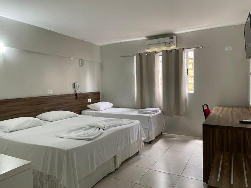 two beds in a hospital room with a window at Requinte Hotel in Altamira