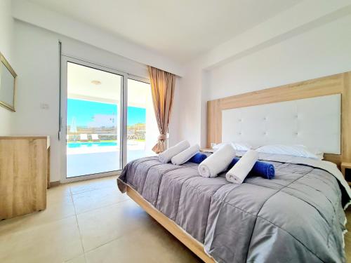 a bedroom with a large bed with a large window at The 4th Seaview Villas in Kiotari