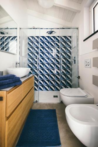 a bathroom with a tub and a sink and a toilet at BLUVARI' Charming House in Alassio