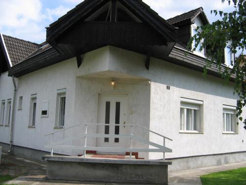 a white house with a staircase in front of it at Barzsó Vendégház in Bogács