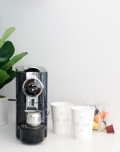 a coffee maker and three cups on a table at The Iris in Charleston