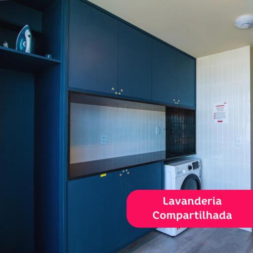 a kitchen with blue cabinets and a washing machine at Liiv Mar - Natal Ponta Negra in Natal