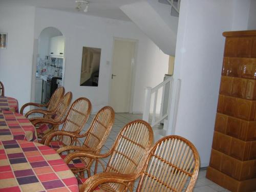 a dining room with a table and chairs and a kitchen at Barzsó Vendégház in Bogács