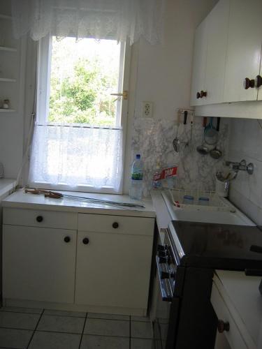 a small kitchen with a window and a sink at Barzsó Vendégház in Bogács