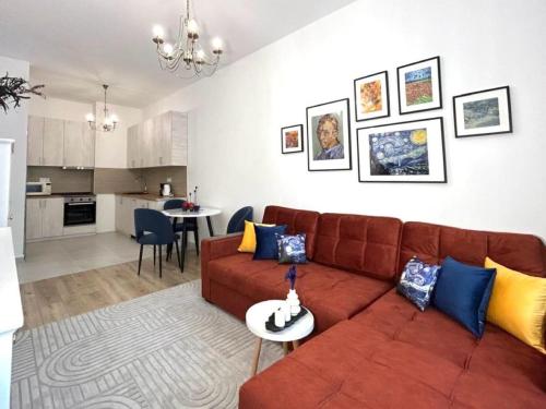 a living room with a brown couch and a kitchen at Apart Complex Meridian из 10 отдельных апартаментов рядом с Арбатом in Almaty