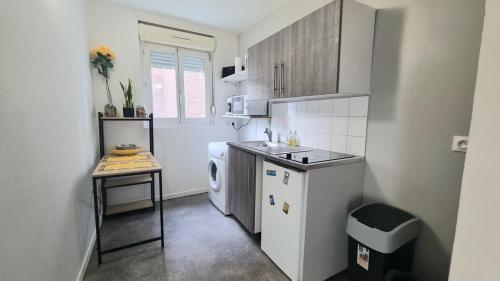 Il comprend une petite cuisine équipée d'un évier et d'un lave-vaisselle. dans l'établissement Chez K&D T2 Jaune Le Havre, au Havre