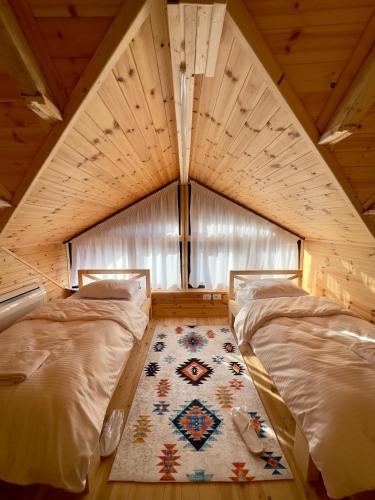 a room with two beds and a rug in a room at Troja Resort - Hotel & Restaurant in Shupenzë