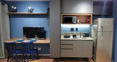 a small kitchen with a table and a refrigerator at STUDIO104 - Novo e completo na melhor localização de Pinheiros, próximo ao Metrô Fradique Coutinho in Sao Paulo