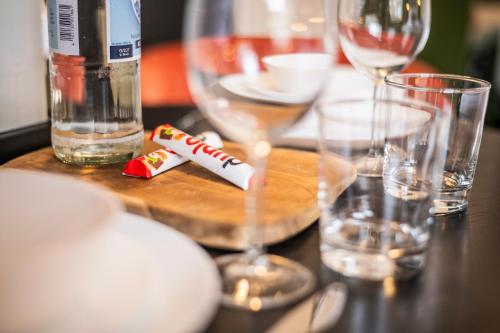 a wooden table with glasses and a bottle of wine at Klassen Stay - Design Apartments direkt am HBF Aachen in Aachen