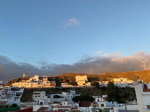a group of white buildings with wind turbines in the background at Casa Salvador in Agaete