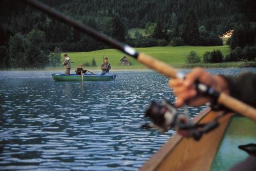 a group of people rowing a boat on a lake at Ferienhof Obergasser und Bergblick in Weissensee