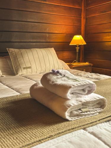 a pile of towels sitting on top of a bed at El Galpón del Glaciar in El Calafate