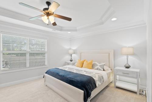 a white bedroom with a bed and a ceiling fan at Urban 2bd Retreat - 15 Mins To Dtwn Knoxville in Knoxville