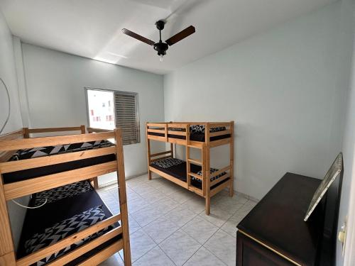 a room with wooden bunk beds and a ceiling fan at Cobertura Frente Mar -Vista mar incrível c garagem e wifi grátis! in São Vicente