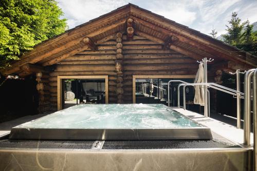 a log cabin with a pool in front of it at Wellness Hotel Alpenhof in Zermatt
