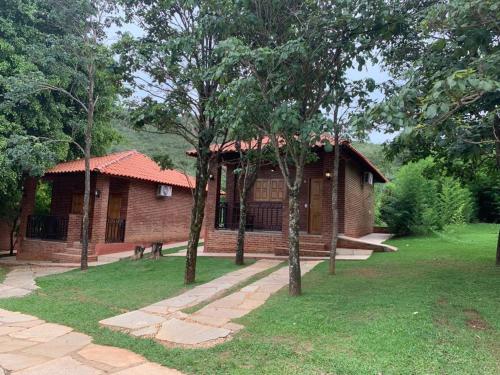 a brick house with trees in front of it at Estalagem Alter Real in Pirenópolis