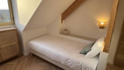 a small bedroom with a white bed in a attic at La Tour en Seine in Les Authieux-sur-le-Port-Saint-Ouen