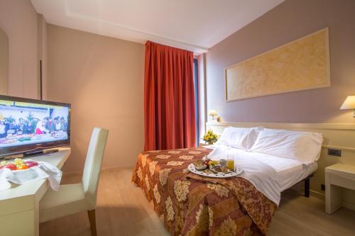 a hotel room with a bed and a flat screen tv at Euro Hotel in Cascina
