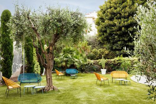 a group of chairs and a tree in a yard at AC Hotel by Marriott Nice in Nice