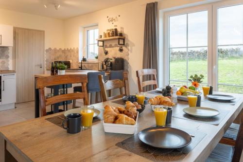 a table with a breakfast of croissants and orange juice at Villa Foret de c'est moi in Bièvre