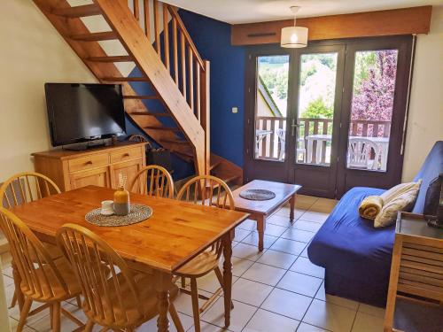 a living room with a dining room table and a couch at Appt T3 calme bord du lac avec piscine in Loudenvielle