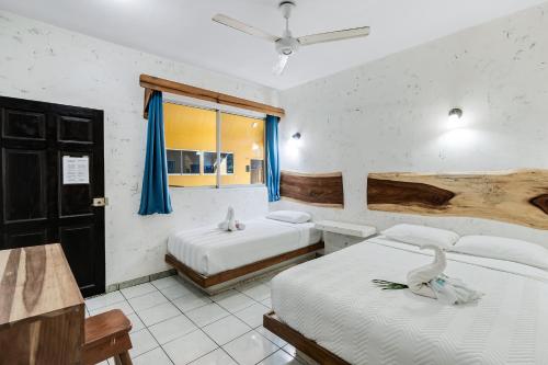 タマリンドにあるHotel Tamarindo INN - 1 mi to Tamarindo Beachのベッドが2つと窓があるホテルの部屋