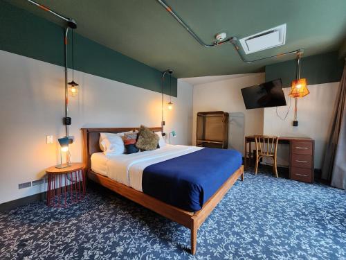 a bedroom with a bed and a desk and a television at Socialtel Parque 93 Bogota in Bogotá