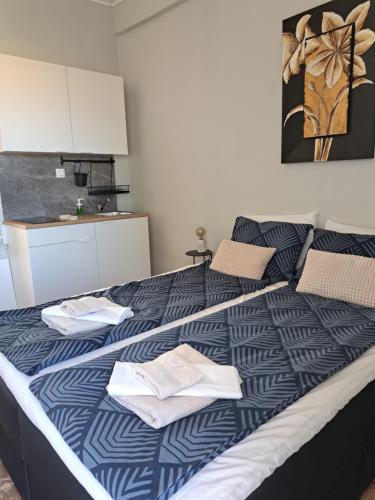 a bedroom with a large bed with blue and white sheets at Garden Rooms in Pírgos Psilonérou