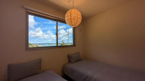 une chambre avec deux lits et une fenêtre dans l'établissement Yonagunijima Hotel Munbu Stay Higawahama - Vacation STAY 14748v, à Sonai