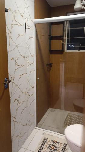 a shower with a glass door in a bathroom at Apartamento com piscina e lazer completo - ideal para família in Caruaru