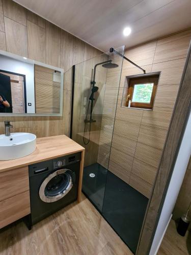 une salle de bain avec douche et machine à laver dans l'établissement Appartement 3 étoiles, meublé, 45m2, station, fibre, Netflix, Disney plus, garage, à Laveissière