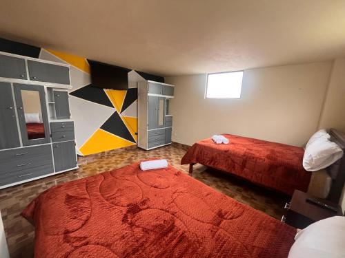 a small bedroom with two beds and a red blanket at Apartamento recien estrenado in Baños