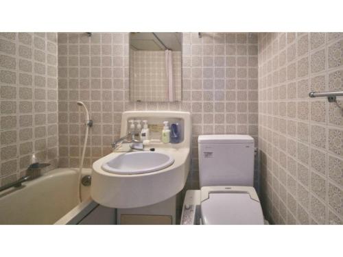 a bathroom with a sink and a toilet and a tub at Ryokan Akebono - Vacation STAY 97660v in Saga