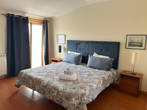 une chambre avec un grand lit avec une tête de lit bleue dans l'établissement Grace Beach House, à Nazaré