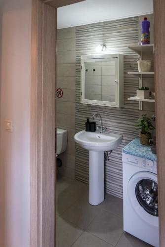 a bathroom with a sink and a washing machine at The Prickly Pear Apartment in Chania