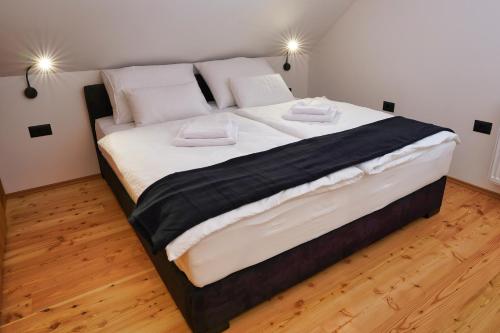 a large bed with two pillows on top of it at Alpine Retreat house Šurc in Rateče