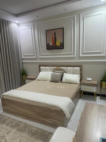 a bedroom with a large bed with white walls at شقه حي شهار الشطبه بالطائف غرفتين in Taif