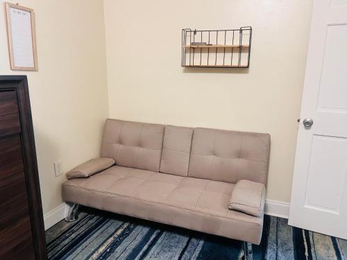 a couch in a living room with a basket on the wall at Simplicity Stays NOLA 2 in New Orleans