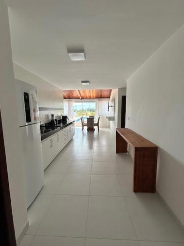 a large white kitchen with a bench in the middle at vila sua casa 2 in Santo André