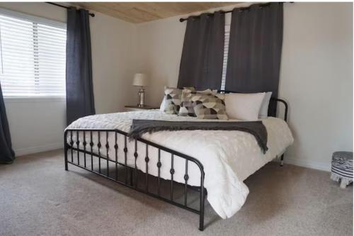 a bedroom with a large bed with black curtains at Chic Country Home in the Woods with Hot Tub in Ruidoso