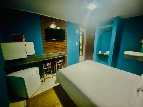 a bedroom with a white bed and a bar at Hotel Atlanta - Salvador - BA in Salvador