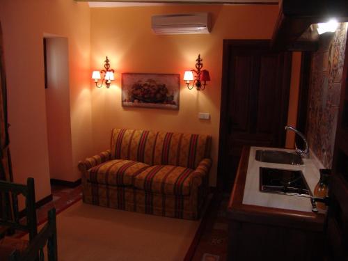 a living room with a couch and a stove at Apartamentos La Columna in Chinchón