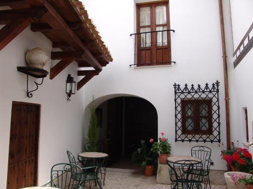 a courtyard with tables and chairs in a building at Apartamentos La Columna in Chinchón