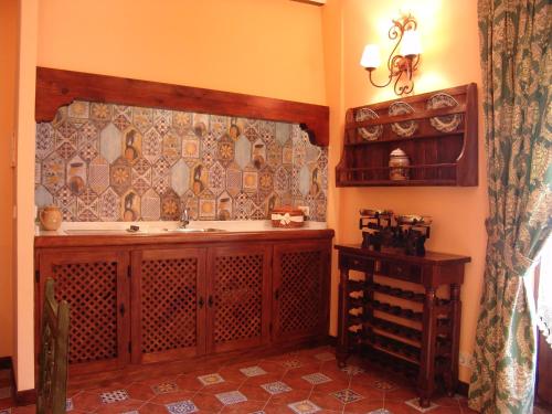 a kitchen with a sink and a tile wall at Apartamentos La Columna in Chinchón