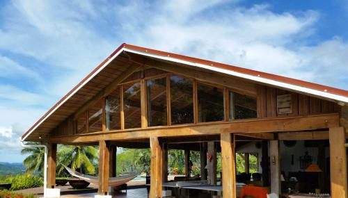 a large wooden house with a boat inside of it at Casa La Paila -- Amazing ocean & mountain views! Staff included! in Carrillo