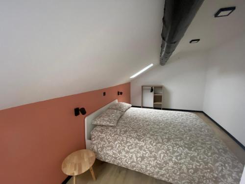 a small bedroom with a bed and a small table at Gite Hertogenwald La spinette in Jalhay
