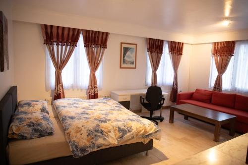 a bedroom with two beds and a red couch at Cozy family home near LottoArena Antwerpen in Antwerp